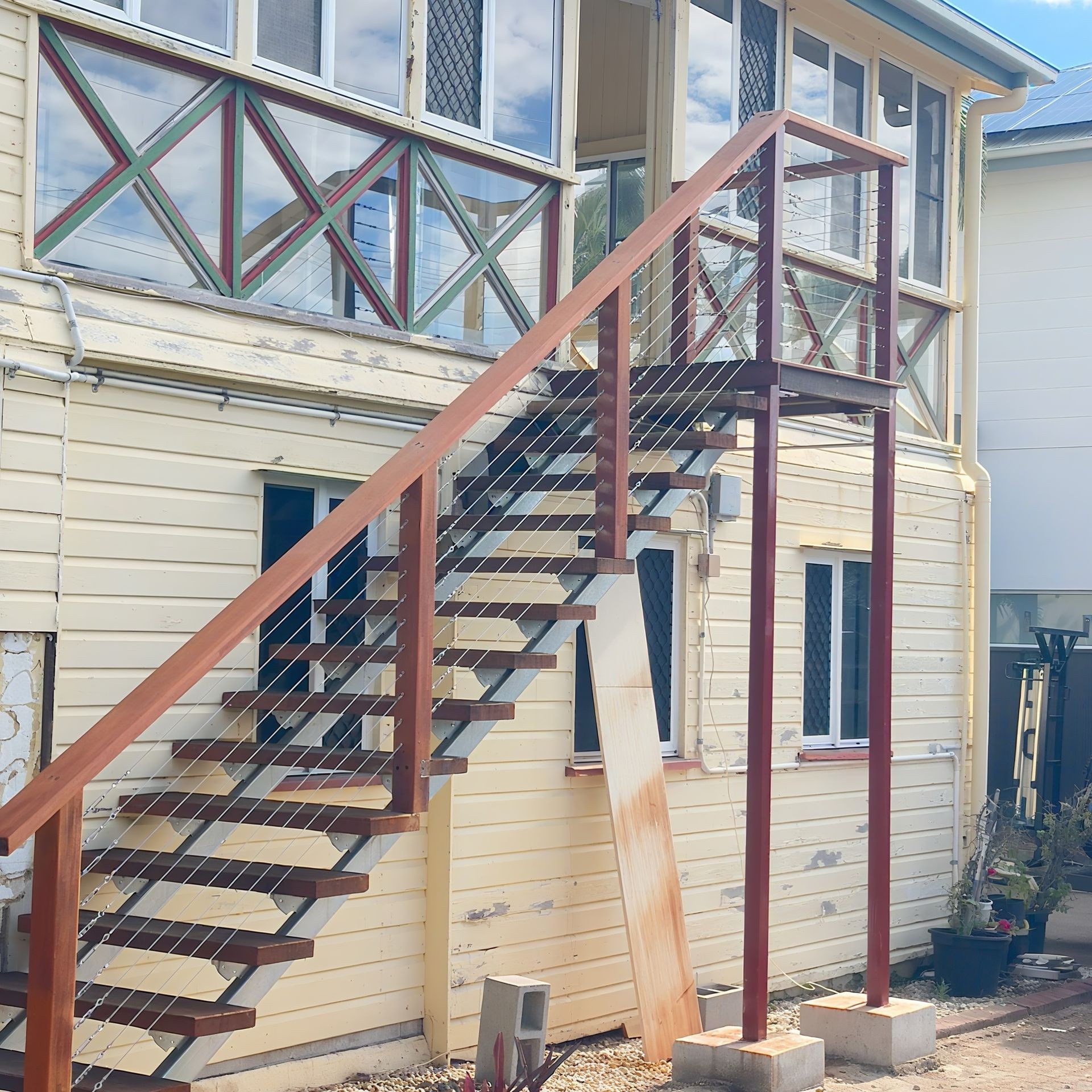 Modern stainless steel wire balustrade installed on outdoor stairs, combining safety and sleek design Newly built external wooden stairs with clean lines and durable materials for safe everyday use Indoor wooden staircase with polished finish and elegant design