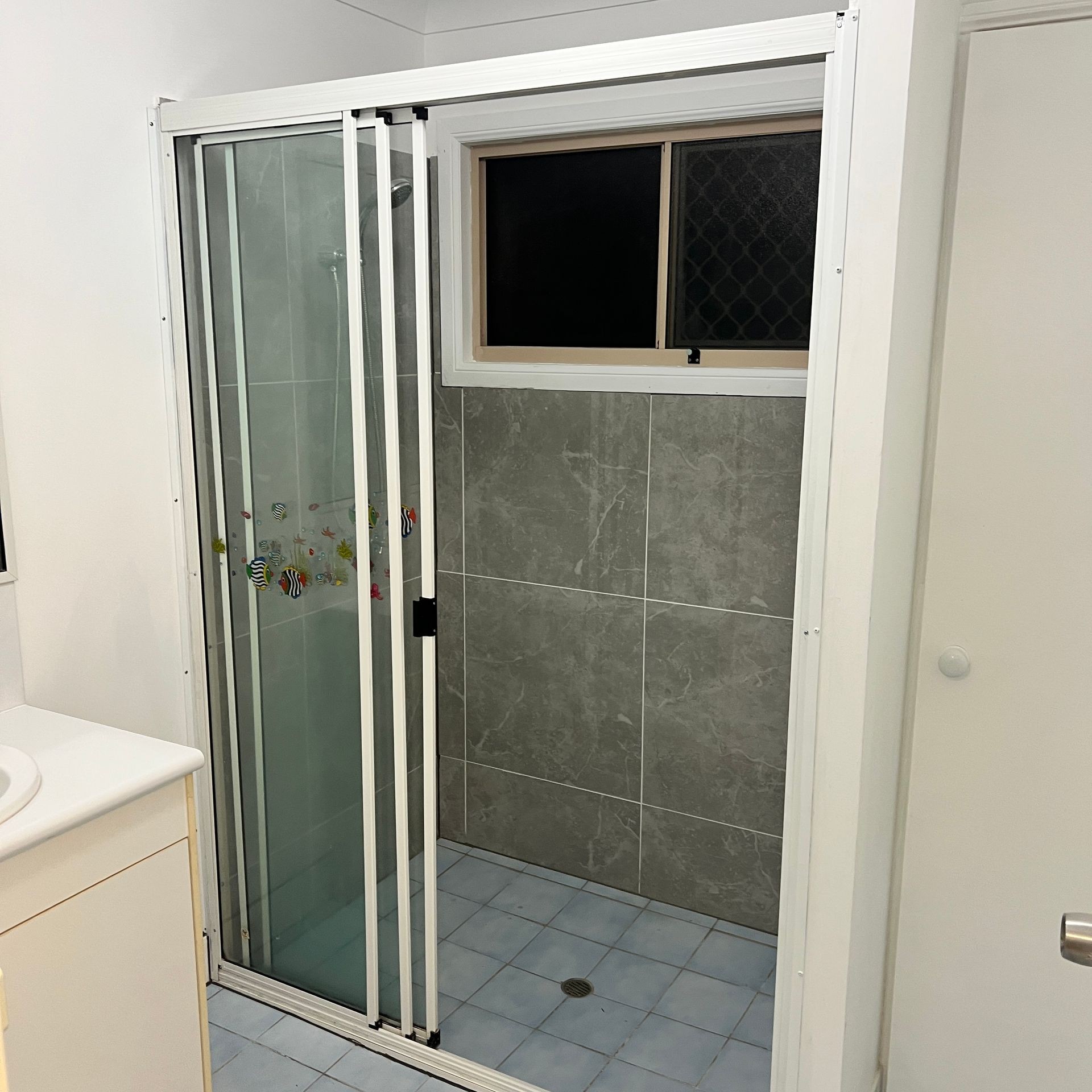 Freshly laid ceramic floor tiles with neat grout lines for a clean and durable surface. Decorative wall tiles in bathroom, highlighting smooth finish and intricate pattern